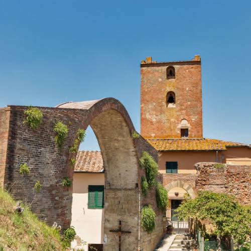 Arco medievale con crocifisso ligneo e la torre del borgo di Montopoli